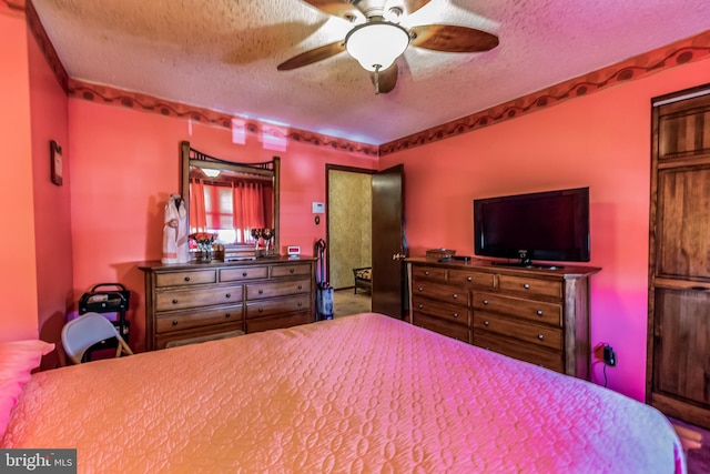 bedroom with ceiling fan and a textured ceiling