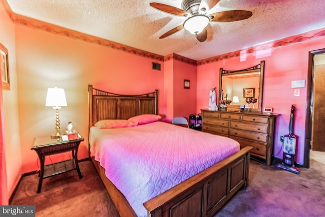 bedroom with dark colored carpet and a textured ceiling