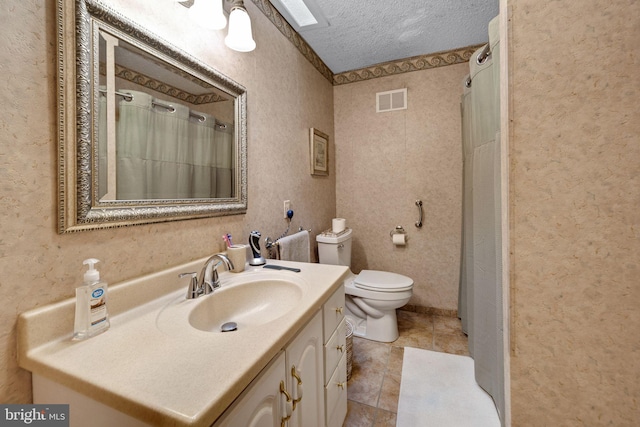 bathroom featuring vanity, toilet, tile patterned flooring, and a textured ceiling