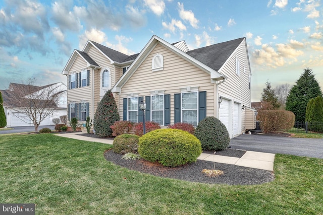 view of property with a garage and a front yard