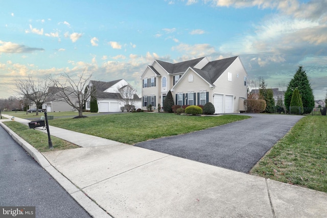 view of property featuring a garage and a front lawn