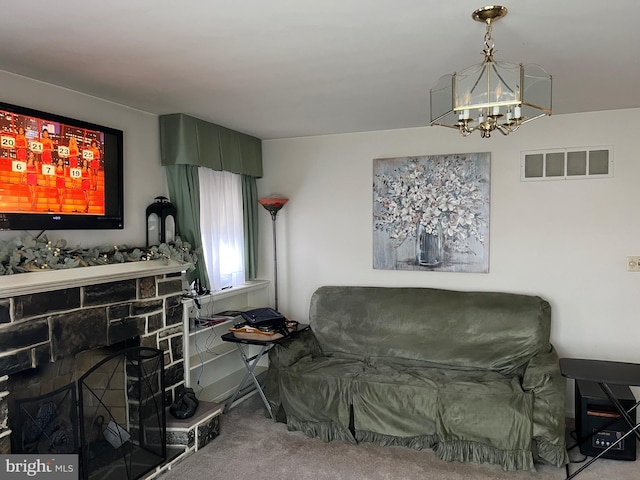 living area with an inviting chandelier, carpet flooring, and a fireplace