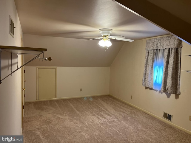 additional living space featuring vaulted ceiling, light carpet, and ceiling fan