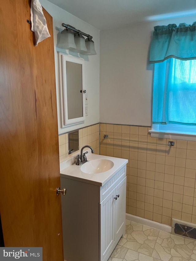 bathroom with vanity and tile walls