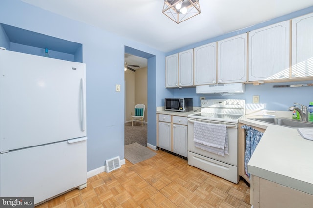 kitchen with sink, white appliances, ceiling fan, light parquet floors, and white cabinets