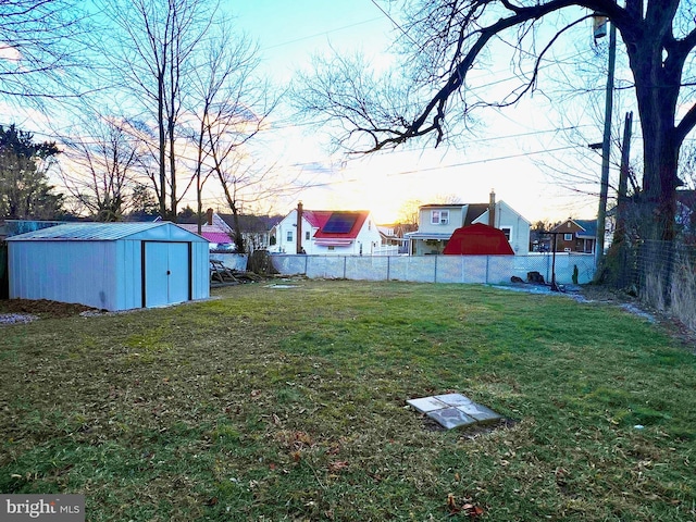 yard at dusk featuring a storage unit