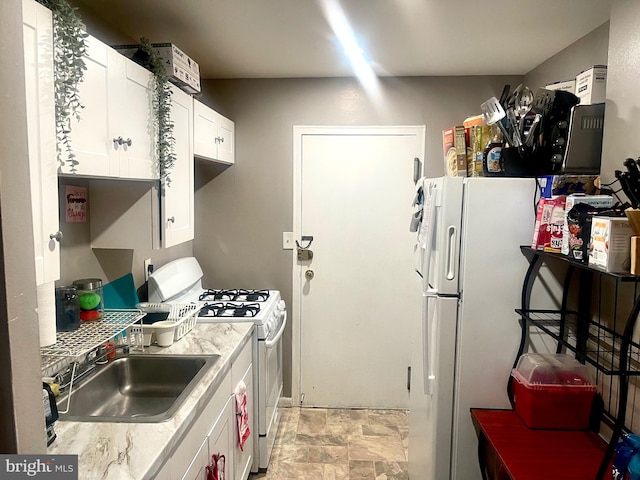 kitchen with white appliances, sink, and white cabinets