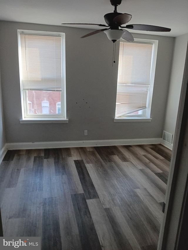 unfurnished room featuring dark wood-type flooring and ceiling fan