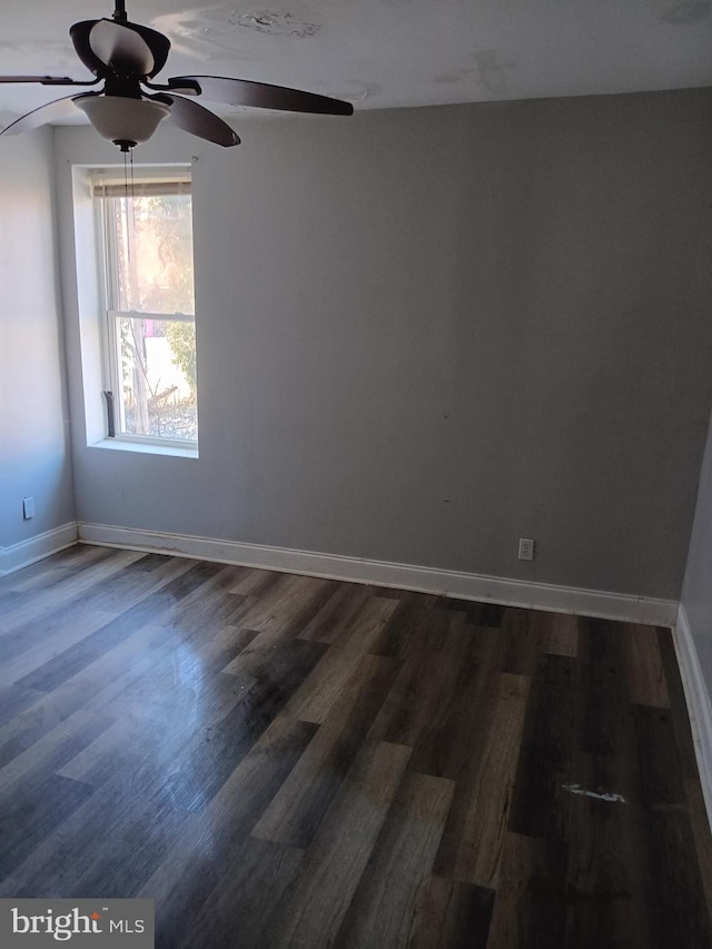 spare room with dark wood-type flooring and ceiling fan