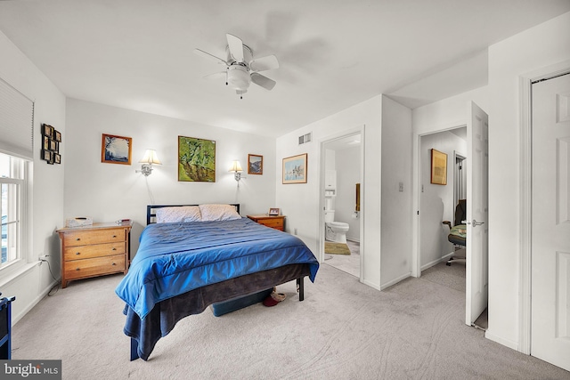 bedroom with light carpet, connected bathroom, and ceiling fan