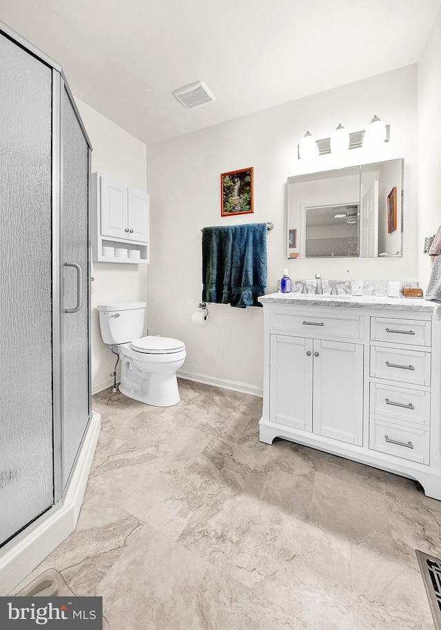 bathroom featuring vanity, an enclosed shower, and toilet