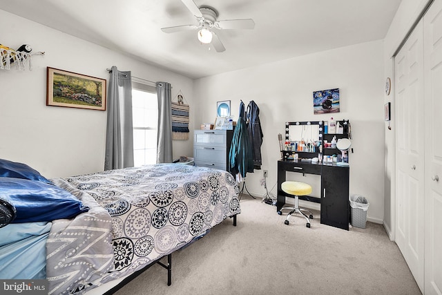 bedroom featuring light carpet, ceiling fan, and a closet