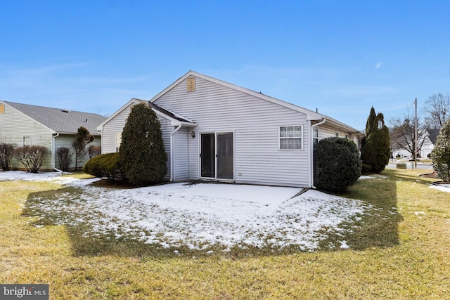 rear view of house featuring a yard