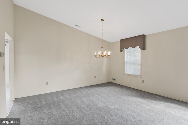 carpeted spare room with lofted ceiling and a notable chandelier