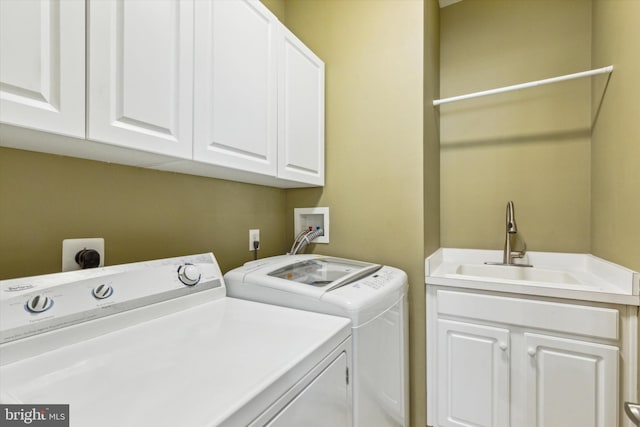 laundry area featuring cabinets, separate washer and dryer, and sink