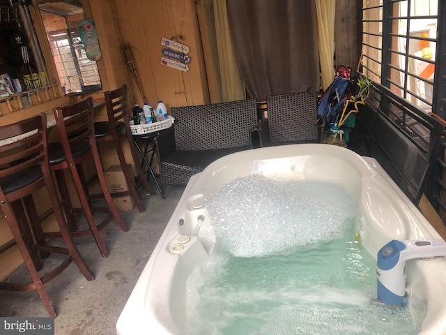 bathroom with a washtub and wood walls