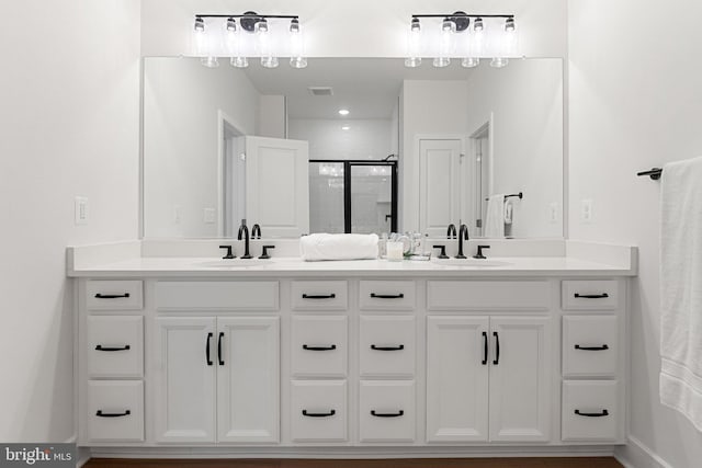 bathroom featuring vanity and a shower with door