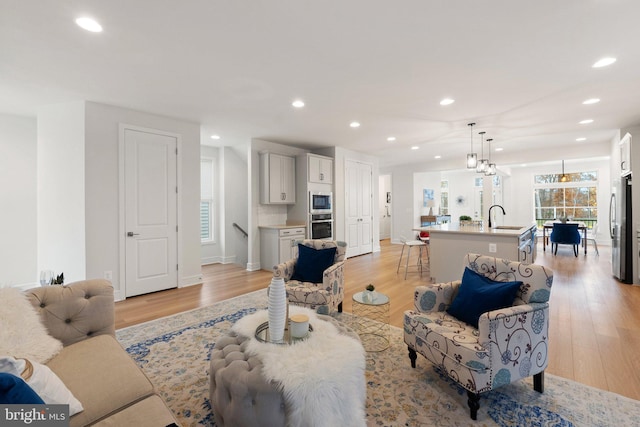 living room featuring sink and light hardwood / wood-style flooring