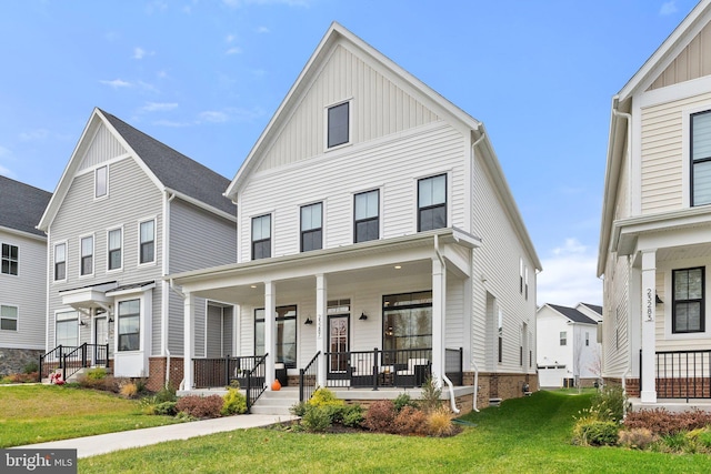 view of property featuring covered porch and a front yard