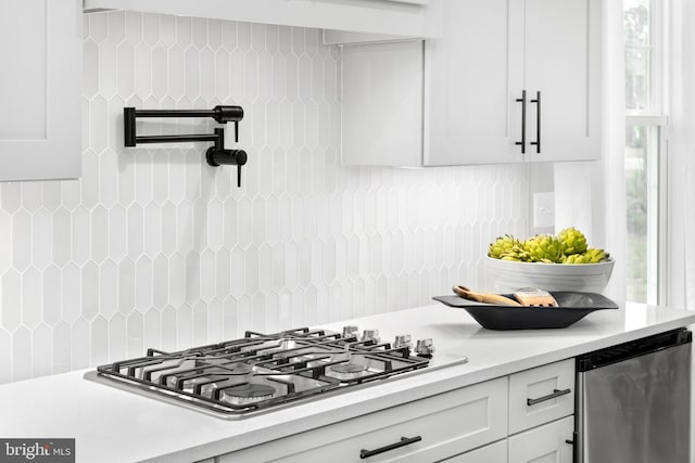 kitchen featuring white cabinetry, stainless steel gas stovetop, and backsplash