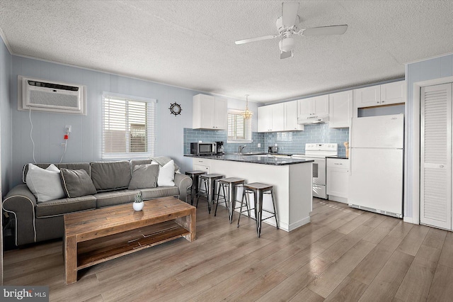 living room with ceiling fan, plenty of natural light, sink, and light hardwood / wood-style floors