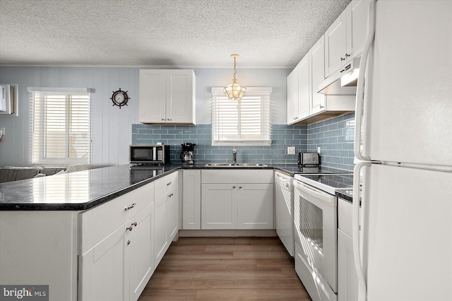 kitchen with sink, white cabinets, white appliances, kitchen peninsula, and light wood-type flooring