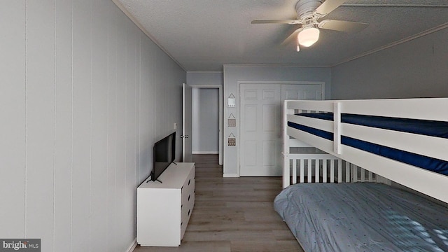 bedroom featuring ornamental molding, a textured ceiling, ceiling fan, and light hardwood / wood-style flooring