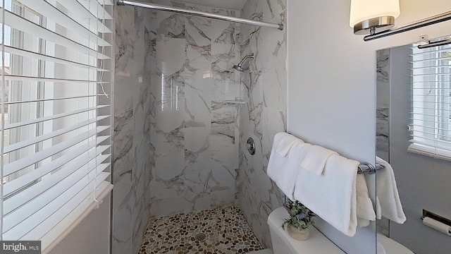 bathroom with toilet and a tile shower