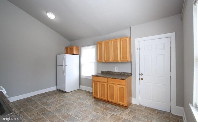 kitchen featuring vaulted ceiling and white fridge