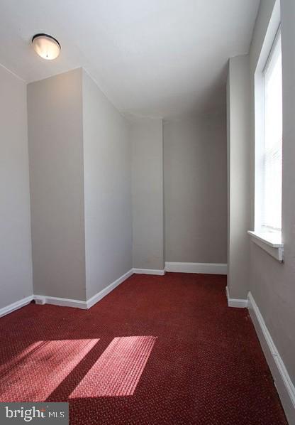 spare room featuring dark colored carpet