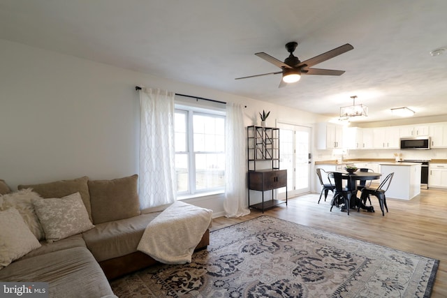 living room featuring light hardwood / wood-style floors and ceiling fan