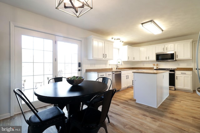 kitchen featuring stainless steel appliances, a kitchen island, and white cabinets