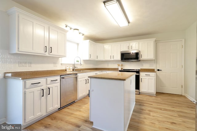 kitchen with white cabinetry, stainless steel appliances, and a center island