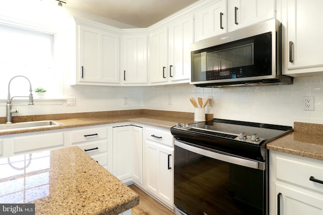 kitchen featuring stainless steel appliances, white cabinetry, and sink