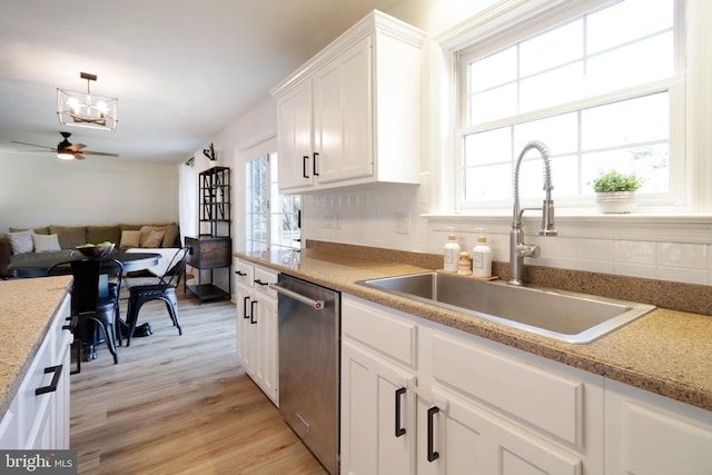 kitchen with pendant lighting, dishwasher, sink, white cabinets, and light hardwood / wood-style floors