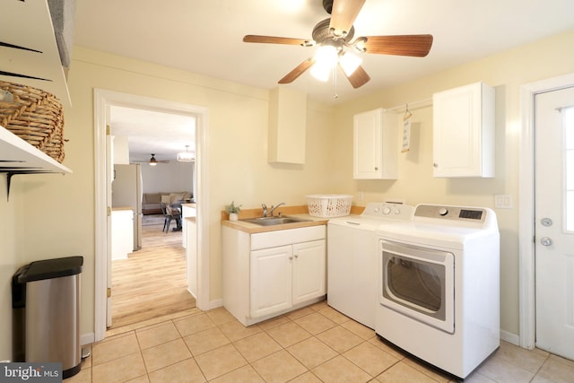 laundry room featuring light tile patterned flooring, sink, cabinets, ceiling fan, and independent washer and dryer