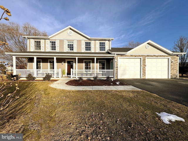 view of front of home with a garage, a porch, and a front yard