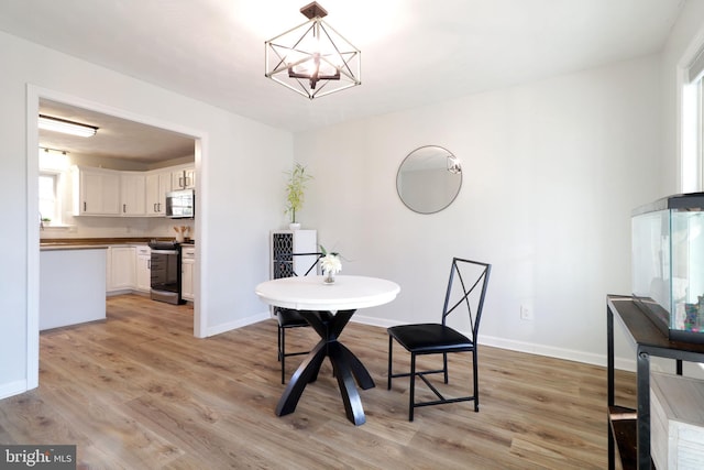 dining room with a notable chandelier and light wood-type flooring