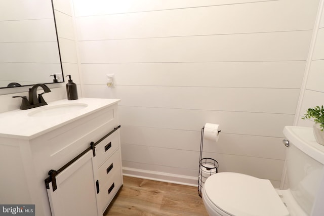 bathroom featuring vanity, wood-type flooring, and toilet