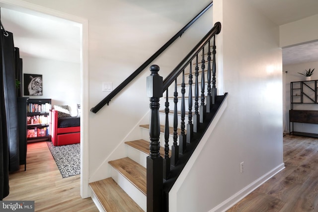 staircase with hardwood / wood-style floors