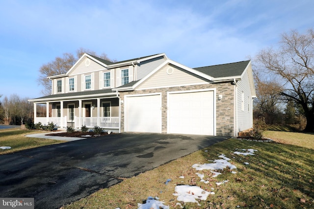 view of front facade featuring a garage, a front yard, and a porch