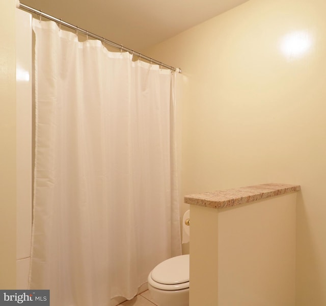 bathroom with tile patterned flooring and toilet