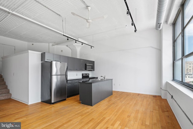 kitchen with high vaulted ceiling, plenty of natural light, stainless steel appliances, and light wood-type flooring