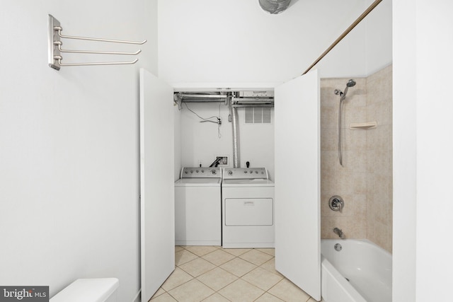 bathroom featuring tiled shower / bath combo, tile patterned floors, toilet, and washing machine and clothes dryer