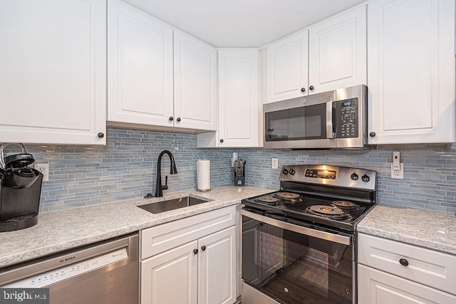 kitchen featuring sink, decorative backsplash, stainless steel appliances, and white cabinets