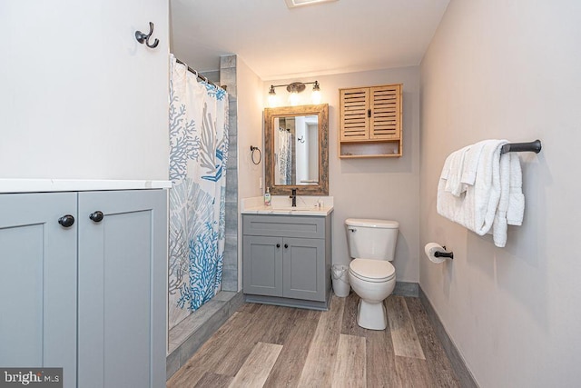 bathroom featuring vanity, hardwood / wood-style floors, a shower with shower curtain, and toilet