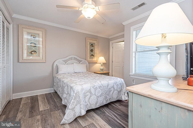 bedroom with ornamental molding, dark hardwood / wood-style floors, ceiling fan, and a closet