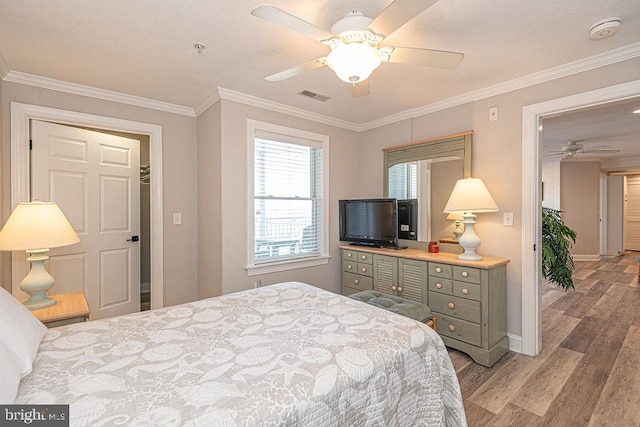 bedroom featuring crown molding, ceiling fan, and light hardwood / wood-style floors