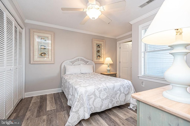 bedroom featuring dark wood-type flooring, ornamental molding, a closet, and ceiling fan