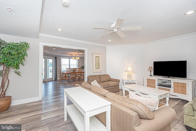 living room featuring ornamental molding, hardwood / wood-style floors, ceiling fan, and a textured ceiling